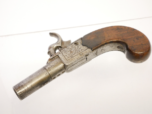 A lovely early 19th-century English 40-bore boxlock percussion muff pistol by Henry Nock of London, converted from flintlock and with the original sliding safety catch removed. It features a 1.5-inch turn-off barrel bearing Birmingham proof marks, while the action is finely engraved with war trophies and signed “H. Nock, London.”