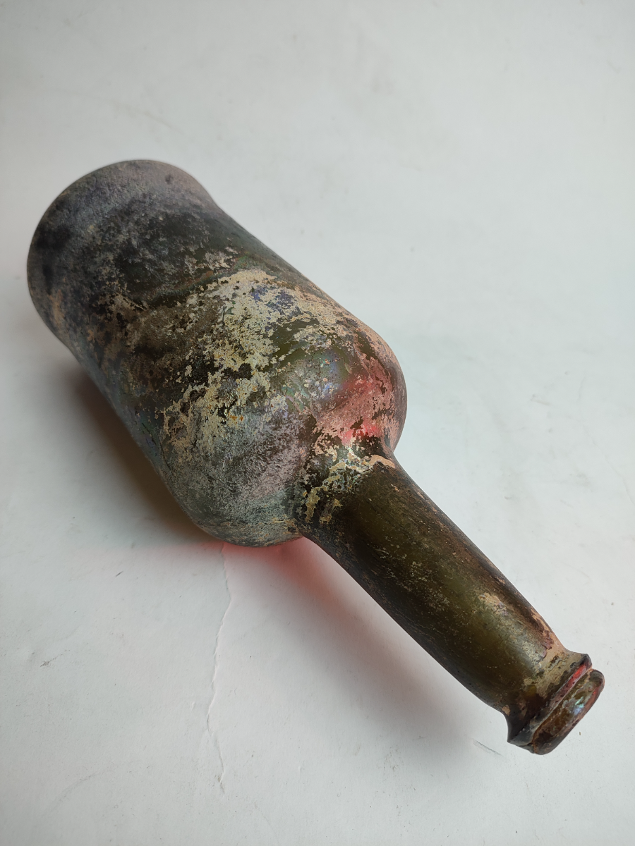 Discover our 18th century green glass wine bottle, dated 1790-1820, standing at 27 cm tall. Shop now for this unique, excavated and well-preserved piece of history!