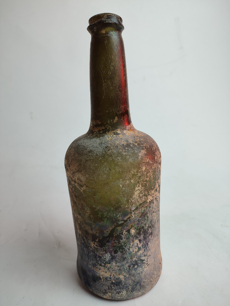 Discover our 18th century green glass wine bottle, dated 1790-1820, standing at 27 cm tall. Shop now for this unique, excavated and well-preserved piece of history!