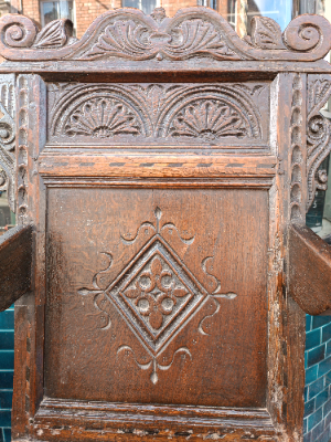 Discover our rare 17th-century oak wainscot armchair from Leeds, Yorkshire. Admire its high-quality scroll-carved top rail, lozenge-carved panel, and check inlaid border. Shop now!