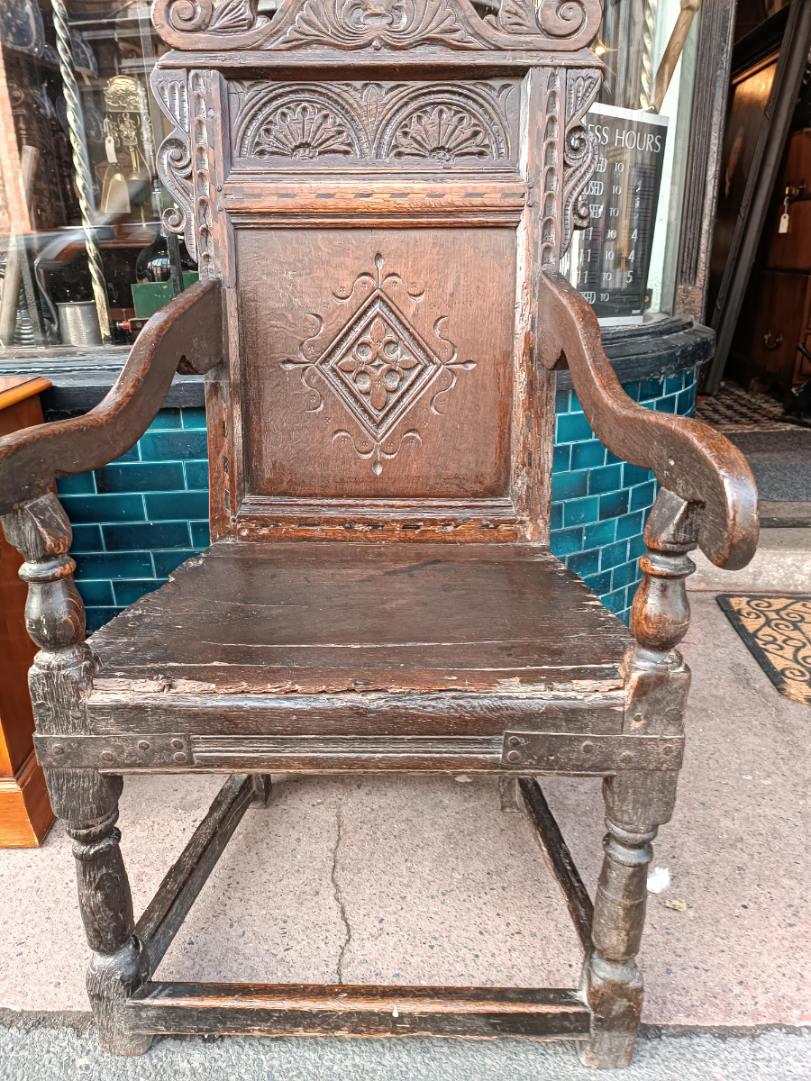 Discover our rare 17th-century oak wainscot armchair from Leeds, Yorkshire. Admire its high-quality scroll-carved top rail, lozenge-carved panel, and check inlaid border. Shop now!
