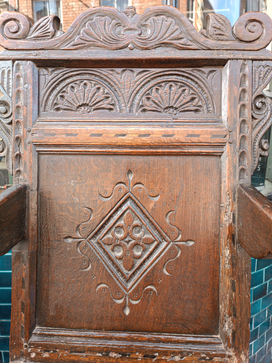 Discover our rare 17th-century oak wainscot armchair from Leeds, Yorkshire. Admire its high-quality scroll-carved top rail, lozenge-carved panel, and check inlaid border. Shop now!