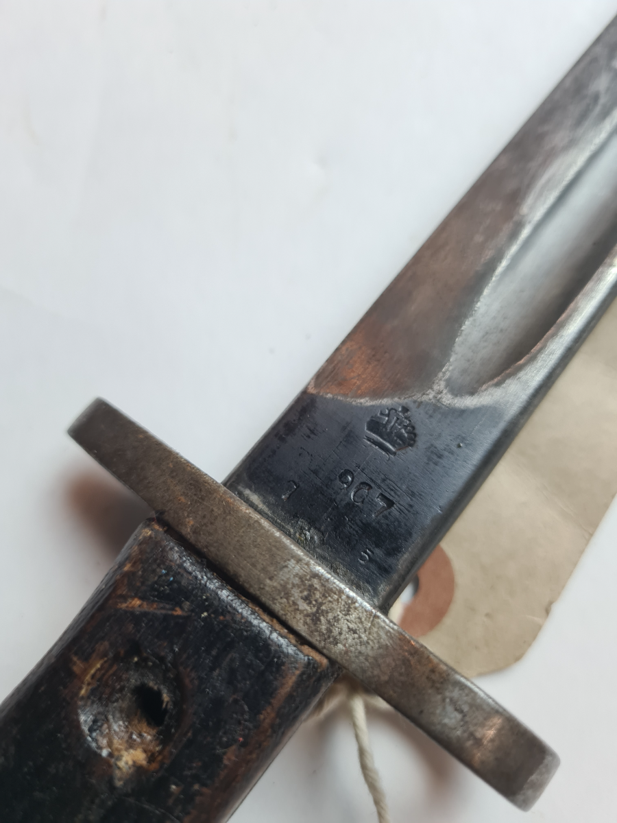 Explore authentic British 1907 bayonet, dated July 1915 with Enfield stamps. Buy now to own a piece of history, despite missing grip screws.