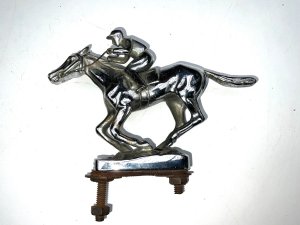 Super item from the roaring twenties comes this fantastic car mascot in the shape of a jockey at gallop on horse, overall conditions good, length of 15 cm height 11 cm width being 34 mm,