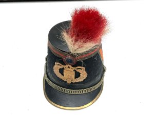 Original french officer's kepi hat french third republic republican guard model 1874 shako by barrau paris with 'paris arms' helmet plate. The french third republic was france from 1870, when the second french empire collapsed, to 1940, when france's defeat by nazi germany led to the vichy france government. Vichy was replaced by the french fourth republic. This is an original french third republic, republican guard model 1874 shako. It has a dark blue cloth over a hard body with red cloth tape chevrons on either side and around the crown, accented with gilt lace. It has a black patent leather crown and holed metal ventilation inserts. It has a patent brim with brass reinforced rim, brass chin chain with grenadier ignited grenade bosses. It has a brass city of paris front plate underneath a tri-color cockade.