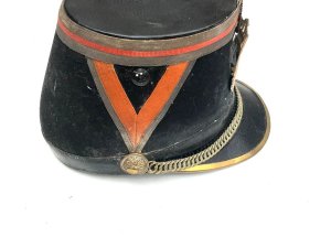 Original french officer's kepi hat french third republic republican guard model 1874 shako by barrau paris with 'paris arms' helmet plate. The french third republic was france from 1870, when the second french empire collapsed, to 1940, when france's defeat by nazi germany led to the vichy france government. Vichy was replaced by the french fourth republic. This is an original french third republic, republican guard model 1874 shako. It has a dark blue cloth over a hard body with red cloth tape chevrons on either side and around the crown, accented with gilt lace. It has a black patent leather crown and holed metal ventilation inserts. It has a patent brim with brass reinforced rim, brass chin chain with grenadier ignited grenade bosses. It has a brass city of paris front plate underneath a tri-color cockade.