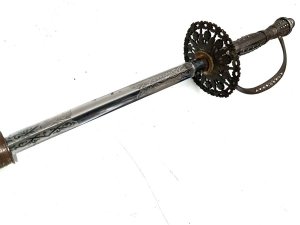 Early 18th century, this gentleman's swords in quite good condition, the three edged blade has the odd blemish that will polish out, the scabbards complete though showing some restoration, the overall length from tip to tips 99 cm across the guard is 7 cm height at guard being 9 cm blades from steels tip to top of handles 97cm and is beautifully engraved on all three edges,