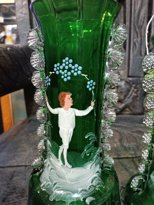 A large Mary Gregory green vase depicting a boy juggling with blue enamel flowers polychrome image.  Size  28 cm high.