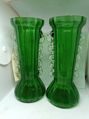 A pair of Mary Gregory green vases depicting a boy and a girl holding the flower.  Size 18 cm high.