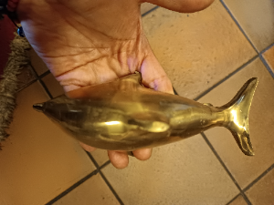 A  dolphin shaped brass door knocker completed with bolt fittings. Size 17 cm long.