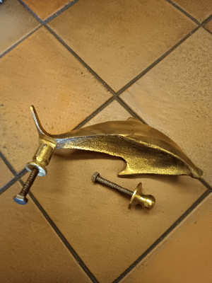 A  dolphin shaped brass door knocker completed with bolt fittings. Size 17 cm long.