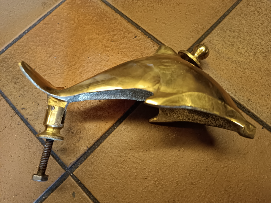 A Solid Dolphin Shaped Brass Door Knocker Completed With Bolt Fittings.