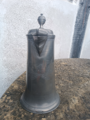 An 18th c. German pewter Flagon of tapering form, decorated with flowers and foliage around the monogram J. C. A and dated 1817.  Size 25 cm high.