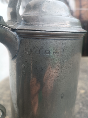 An 18th c.English spouted spire pewter flagon, 
O. E. W. S, half gallon, with plain tapering drum and beaded splayed footing, the double dome lid with acorn finial, a chair back thumb piece and broken- scroll handle with hooded ball terminal, hallmarks , Henry Joseph (PS5435).  Size 32 cm high.
Henry Joseph was born in London 1736 and died 1787)