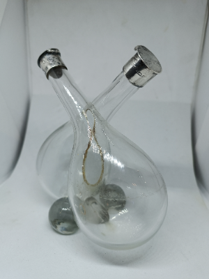 Explore our elegant Edwardian Olive Oil and Vinegar Glass Bottle with Silver Top, hallmarked Birmingham 1910. Order now for a vintage addition to your table setting.