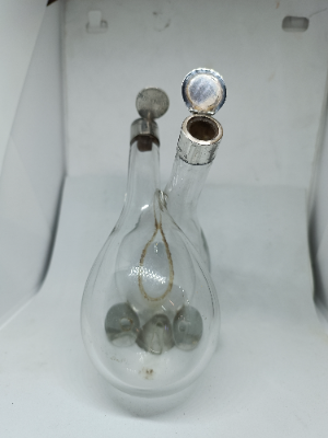 Explore our elegant Edwardian Olive Oil and Vinegar Glass Bottle with Silver Top, hallmarked Birmingham 1910. Order now for a vintage addition to your table setting.