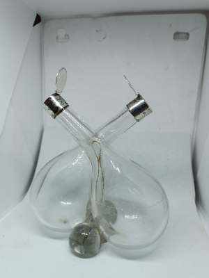 Explore our elegant Edwardian Olive Oil and Vinegar Glass Bottle with Silver Top, hallmarked Birmingham 1910. Order now for a vintage addition to your table setting.
