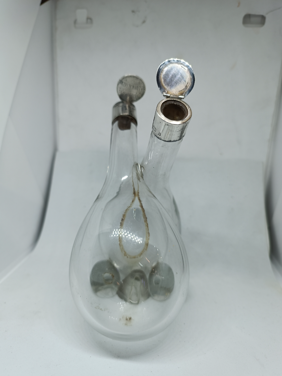 Explore our elegant Edwardian Olive Oil and Vinegar Glass Bottle with Silver Top, hallmarked Birmingham 1910. Order now for a vintage addition to your table setting.