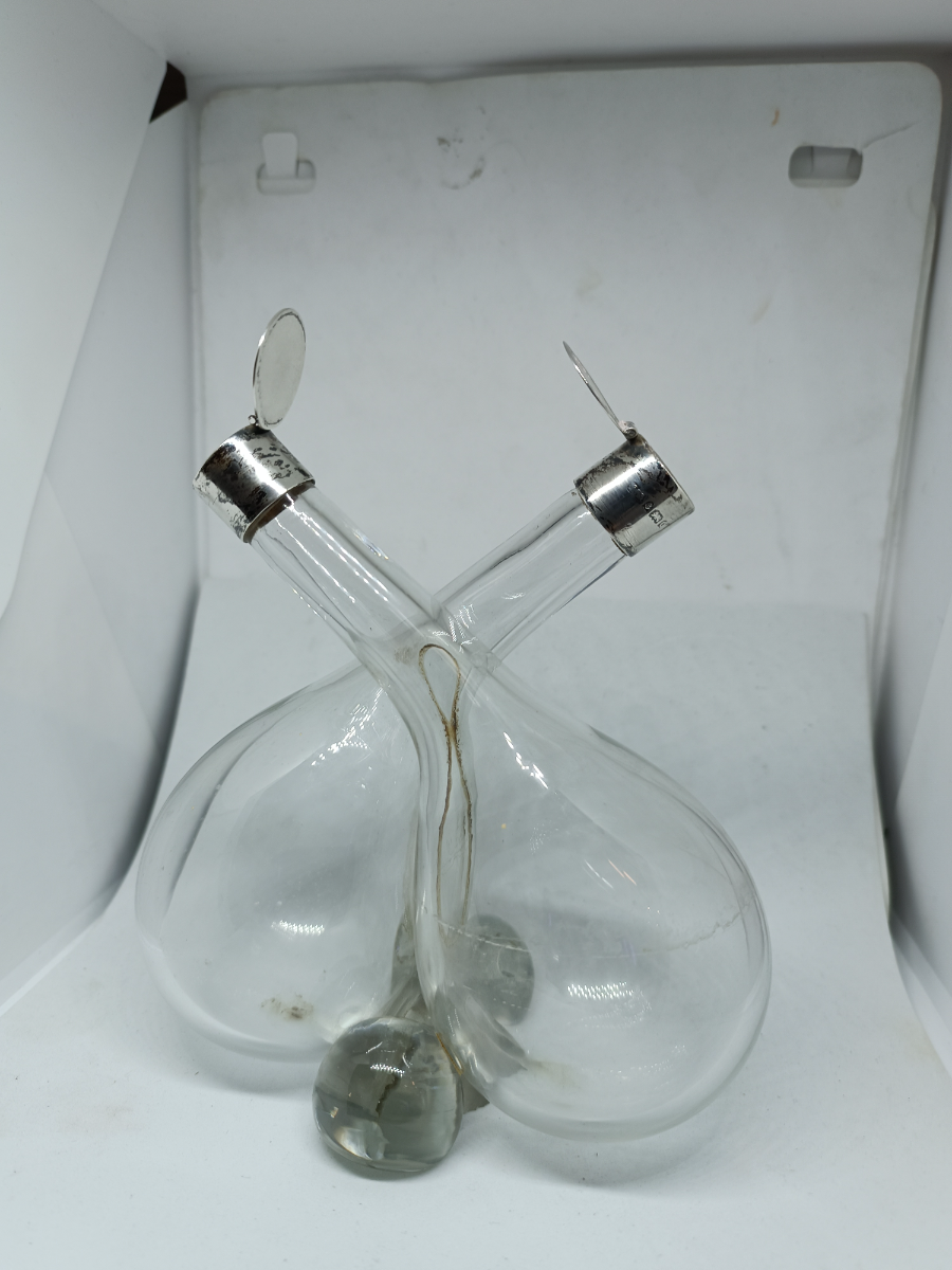 Explore our elegant Edwardian Olive Oil and Vinegar Glass Bottle with Silver Top, hallmarked Birmingham 1910. Order now for a vintage addition to your table setting.