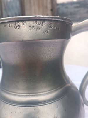 An antique English  one  full gallon pewter measure with the crown  over VR means it was originally made and verified in late Victoria era ( 1837-1901) and remainaed in active commercial service in a British pub through WWI. No maker marks except the crown above VR502 which means it was later verified in Lancashire.
Size. 26.5 cm high .