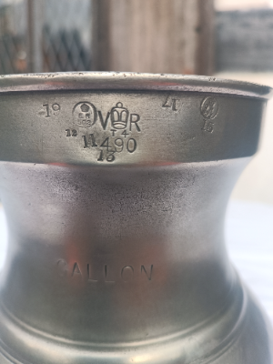 An antique English  one  full gallon pewter measure with the crown  over VR means it was originally made and verified in late Victoria era ( 1837-1901) and remainaed in active commercial service in a British pub through WWI. No maker marks except the crown above VR502 which means it was later verified in Lancashire.
Size. 26.5 cm high .