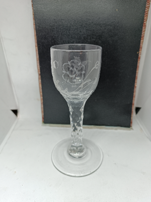 Early nineteen century English drinking glass, facet cut stem and wheel cut engraving with fantasy bird and flower on the bowl, with pontil mark at the base. Size 13.5 cm high.