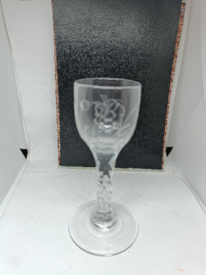 Early nineteen century English drinking glass, facet cut stem and wheel cut engraving with fantasy bird and flower on the bowl, with pontil mark at the base. Size 13.5 cm high.