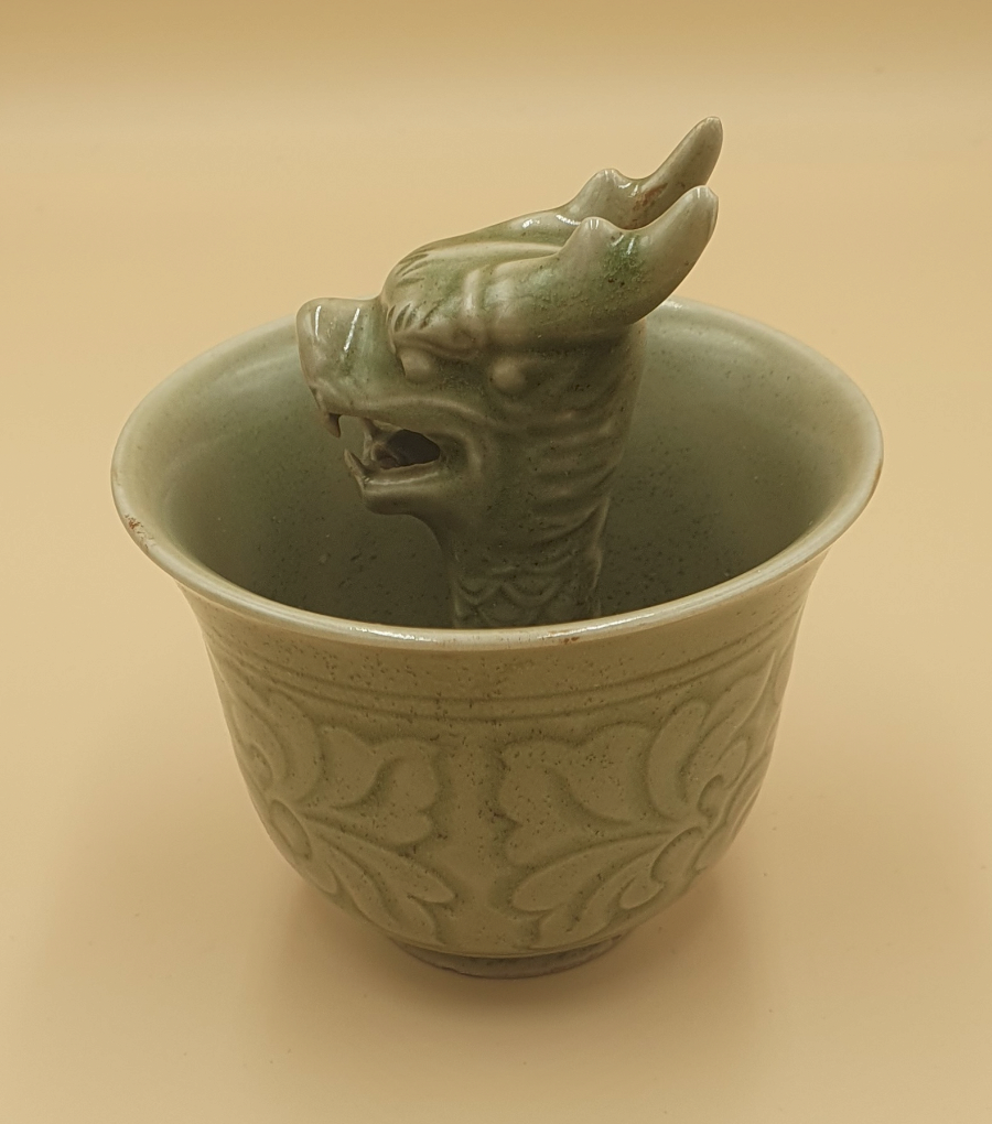 Discover our vintage porcelain dragon cups. Perfectly glazed in Celadon, these 'greedy cups' embody moderation & wisdom. Don't overfill, or it empties! Experience this magical ceramic art now.
