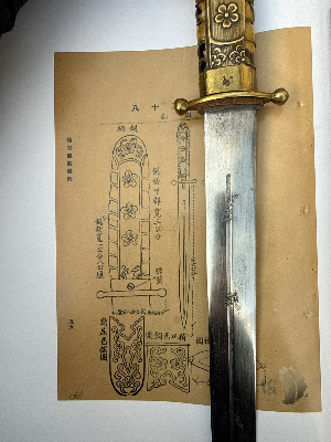For sale is a rare “Plum Blossom Sword”, a pattern prescribed for Chinese Nationalist Army officers under the 1936 uniform regulations. The sword takes its name from the three plum blossoms decorating its handle. Most surviving examples are in poor condition.

In January 1936, the National Government introduced uniform regulations establishing a standard pattern for army officers’ swords. The commemorative swords presented in June 1936 to graduates of the Tenth First Corps of the Central Army Officer Academy followed this pattern.

During his rule, Chiang Kai-shek was known for presenting quality swords to dignitaries and commanding officers. He also introduced uniform regulations for officers, to which this example conforms.

Although comparable in size to a knife, this weapon is classified as a short sword under Chinese Army regulations. No provenance.

**Condition:**  
In excellent overall condition, retaining the original finish on the scabbard, with very light pitting to the blade, as shown in the photographs.

**Reference:**  
*Chinese Nationalist Officers’ Daggers in World War II: 80th Anniversary of Victory in the War of Resistance Against Japan and the Retrocession of Taiwan*, published in 2026. This publication is currently available only in Mandarin Chinese; no English edition is available.

现出售一把罕见的“梅花剑”，其制式依据1936年国民革命军军官服制规定。此剑因剑柄上的三朵梅花装饰而得名，现存实物大多品相欠佳。

1936年1月，国民政府颁布服制条例，确立了陆军军官佩剑的标准制式。同年6月，中央陆军军官学校第十期第一总队毕业生获颁的毕业纪念剑，亦采用了这一制式。

蒋介石主政期间，常将精制佩剑赠予政要及高级军官。他还推行了统一的军官服制规定，本件藏品即符合该制式。

虽然尺寸与匕首相近，但根据当时中国陆军的相关规定，此类兵器被归类为短剑。

**品相：**  
整体品相极佳，剑鞘保留原有表面处理，剑身仅有轻微麻点状锈蚀，具体情况如照片所示。

**参考文献：**  
《第二次世界大战中的中国国民革命军军官短剑：抗日战争胜利暨台湾光复80周年纪念》（书名暂译），2026年出版。该书目前仅有中文版，尚无英文版。