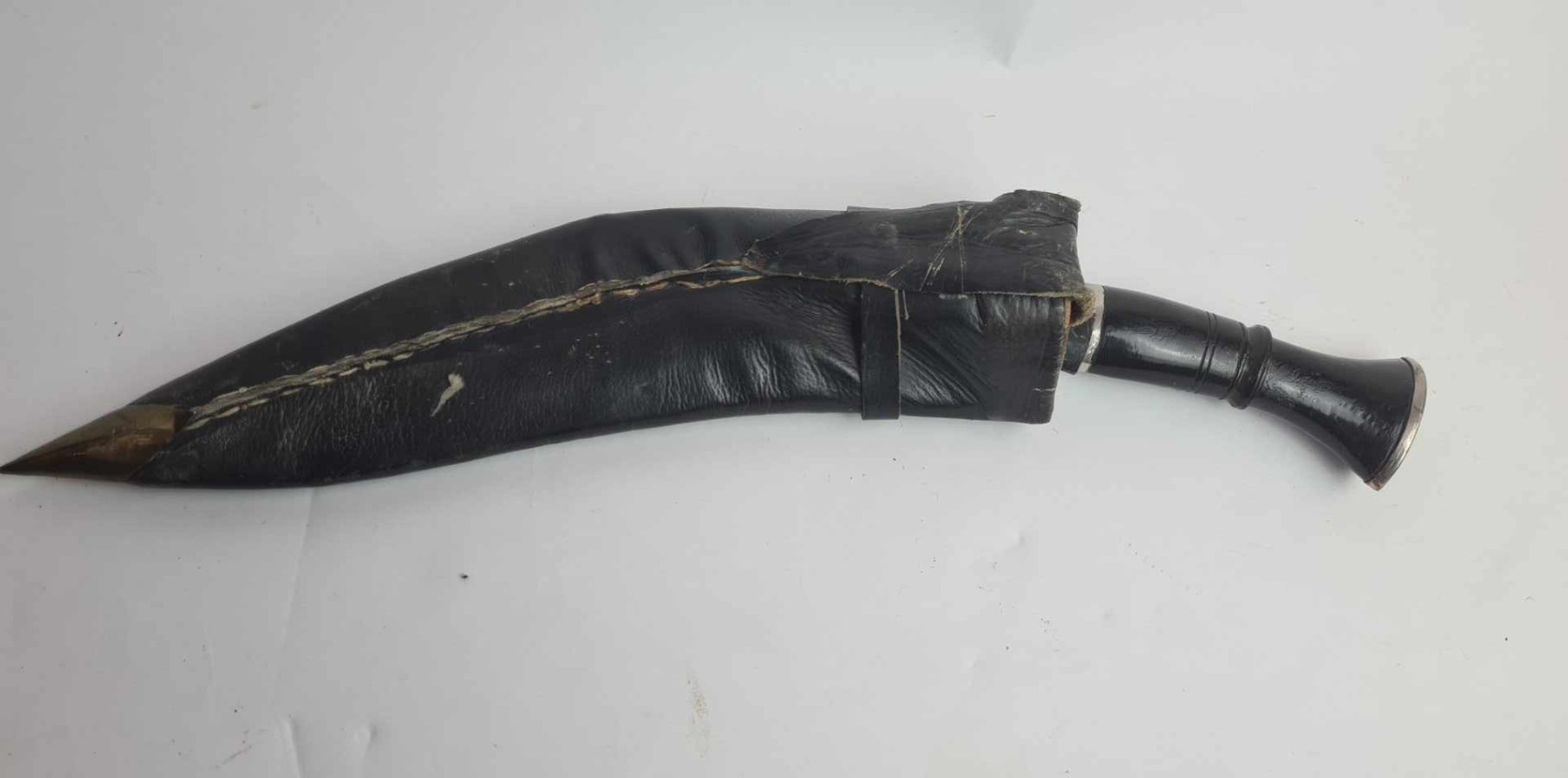 Discover our exceptional range of antique kukris! Experience owning a piece of history with our early to mid 20th-century bone-handled kukri, complete with a black leather sheath and two knives. Shop now!