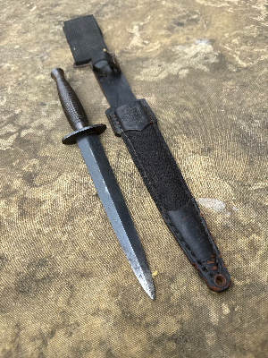 A nice Third Pattern Fairbairn-Sykes example without a heat stamp, suggesting post-war production rather than wartime manufacture. Probably by Wilkinson
 Of particular interest is the sold-out-of-service stamp on the guard, indicating that the knife was formally disposed of from British military stocks and sold to the Indonesian Kopassus Special Forces (due to scabbard being marked Kopassus with the army logo).

This blade appears to be an earlier ex-British Army issue knife, later sold or transferred to Indonesia. It predates the modern Kopassus, which took its present name in the mid-1980s. Indonesia’s Army special forces have much earlier roots in KKAD and later RPKAD (Resimen Para Komando Angkatan Darat), elite commando formations tasked with special operations, reconnaissance, airborne missions and counter-insurgency, often operating in small units in difficult terrain. These predecessor units eventually evolved into today’s Kopassus.

History:

The Third Pattern Fairbairn-Sykes appeared in October 1943 and represented a further simplification of the famous fighting knife for large-scale wartime production.

One of the most recognisable features of the Third Pattern is its redesigned handle, formed with 27 stacked concentric rings. By this stage Wilkinson had moved away from brass, which remained a strategically important material, and instead adopted a less restricted alloy. The grip could be cast in a single operation, reducing the additional remedial machining and finishing required on earlier patterns.

The Third Pattern also introduced the distinctive triangular-shaped ricasso or flat at the rear of the blade, immediately ahead of the guard, another useful identifying feature of the pattern.

As wartime demand increased, elements of manufacture were increasingly outsourced to specialist firms. Companies involved in the production or casting of Third Pattern handles included Wolverhampton Die Casting Company, Walsall Die Casting Ltd, Henry Bar Metal Co. and H. J. Maybry. Handles are often found with numbers or other identifying marks associated with their manufacturer or production source.

A useful rule of thumb when assessing Third Pattern examples concerns the heat-stamped markings commonly encountered on wartime knives. Wartime-produced examples are frequently found with such stamps, while unstamped examples are generally associated with post-war production, although individual knives should always be assessed on the totality of their construction and markings rather than on a single feature alone.