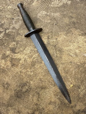A nice Third Pattern Fairbairn-Sykes example without a heat stamp, suggesting post-war production rather than wartime manufacture. Probably by Wilkinson
 Of particular interest is the sold-out-of-service stamp on the guard, indicating that the knife was formally disposed of from British military stocks and sold to the Indonesian Kopassus Special Forces (due to scabbard being marked Kopassus with the army logo).

This blade appears to be an earlier ex-British Army issue knife, later sold or transferred to Indonesia. It predates the modern Kopassus, which took its present name in the mid-1980s. Indonesia’s Army special forces have much earlier roots in KKAD and later RPKAD (Resimen Para Komando Angkatan Darat), elite commando formations tasked with special operations, reconnaissance, airborne missions and counter-insurgency, often operating in small units in difficult terrain. These predecessor units eventually evolved into today’s Kopassus.

History:

The Third Pattern Fairbairn-Sykes appeared in October 1943 and represented a further simplification of the famous fighting knife for large-scale wartime production.

One of the most recognisable features of the Third Pattern is its redesigned handle, formed with 27 stacked concentric rings. By this stage Wilkinson had moved away from brass, which remained a strategically important material, and instead adopted a less restricted alloy. The grip could be cast in a single operation, reducing the additional remedial machining and finishing required on earlier patterns.

The Third Pattern also introduced the distinctive triangular-shaped ricasso or flat at the rear of the blade, immediately ahead of the guard, another useful identifying feature of the pattern.

As wartime demand increased, elements of manufacture were increasingly outsourced to specialist firms. Companies involved in the production or casting of Third Pattern handles included Wolverhampton Die Casting Company, Walsall Die Casting Ltd, Henry Bar Metal Co. and H. J. Maybry. Handles are often found with numbers or other identifying marks associated with their manufacturer or production source.

A useful rule of thumb when assessing Third Pattern examples concerns the heat-stamped markings commonly encountered on wartime knives. Wartime-produced examples are frequently found with such stamps, while unstamped examples are generally associated with post-war production, although individual knives should always be assessed on the totality of their construction and markings rather than on a single feature alone.