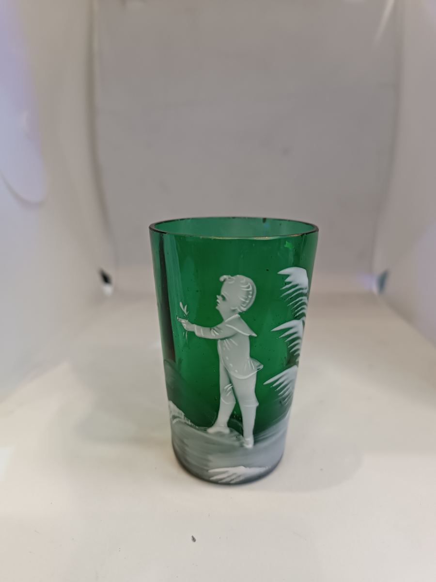 Discover the exquisite Mary Gregory emerald green shot tumbler glass. Perfect condition and featuring a unique design. Dive into antique elegance now.