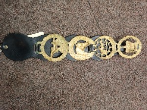 A vintage  4 horse Brasses on leather strap, probably late 19- early 20th century, been used from one equestrian family.  Size  46 cm long.