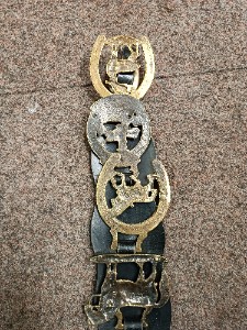 A vintage leather strap containing 4 horse brasses, late 19- early 20th century, also came from one equestrian family.  Size. 43 cm long.
