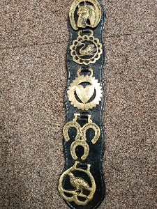 A vintage 5 horse brasses on the leather strap from one equestrian family.  Size  53 cm long.