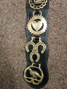 A vintage 5 horse brasses on the leather strap from one equestrian family.  Size  53 cm long.
