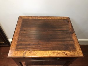 Elegant period antique Sheraton-style side table, circa 1780, featuring a satinwood cross-banded top and a front drawer with original brass handles. One ring handle is missing due to age. Delicate tapered legs are decorated with string inlay, and the drawer has a pine lining. The table has a faded colour and shows signs of wear consistent with age and use. Dimensions: 31.5 inches high × 23 inches wide × 19 inches deep.