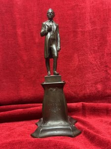 Solid bronze sculpture of U.S. President Abraham Lincoln, titled 'The Emancipator', mounted on an ornate pedestal decorated with floral sprays. Described as originally sculpted by George Edwin Bissell (1839–1920) and cast by the Gotham Foundry. The front of the pedestal bears the inscription 'Power Progress and Freedom'. The reverse is dated 1902 and inscribed 'What I Have Said, I Have Said. I Withdraw Nothing.' Dimensions: 35 cm high × 13 cm wide.