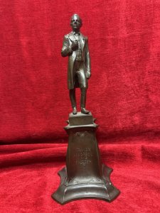 Solid bronze sculpture of U.S. President Abraham Lincoln, titled 'The Emancipator', mounted on an ornate pedestal decorated with floral sprays. Described as originally sculpted by George Edwin Bissell (1839–1920) and cast by the Gotham Foundry. The front of the pedestal bears the inscription 'Power Progress and Freedom'. The reverse is dated 1902 and inscribed 'What I Have Said, I Have Said. I Withdraw Nothing.' Dimensions: 35 cm high × 13 cm wide.