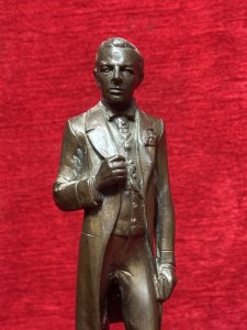 Solid bronze sculpture of U.S. President Abraham Lincoln, titled 'The Emancipator', mounted on an ornate pedestal decorated with floral sprays. Described as originally sculpted by George Edwin Bissell (1839–1920) and cast by the Gotham Foundry. The front of the pedestal bears the inscription 'Power Progress and Freedom'. The reverse is dated 1902 and inscribed 'What I Have Said, I Have Said. I Withdraw Nothing.' Dimensions: 35 cm high × 13 cm wide.