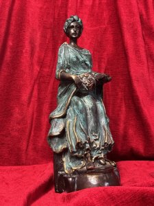 French bronze sculpture of a fruit-bearing goddess, circa 1920. The figure wears a gown with a green verdigris finish. Dimensions: 33 cm high × 15 cm wide × 14 cm deep.