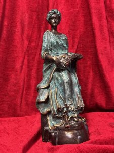 French bronze sculpture of a fruit-bearing goddess, circa 1920. The figure wears a gown with a green verdigris finish. Dimensions: 33 cm high × 15 cm wide × 14 cm deep.