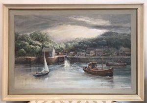 Original oil painting on board depicting a harbour with fishing boats, a canal waterway and houses. Intricate detail and vivid colours capture the waterfront beneath a stormy sky. Signed by Hong Kong-based artist WAN and presented in a cream wooden frame with a painted border.