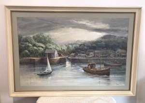 Original oil painting on board depicting a harbour with fishing boats, a canal waterway and houses. Intricate detail and vivid colours capture the waterfront beneath a stormy sky. Signed by Hong Kong-based artist WAN and presented in a cream wooden frame with a painted border.
