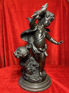 Bronze Sculpture Of Blind Folded Eros With Young Psykhe After Auguste Moreau Circa - 1890 Composition - Bronze Brief History Of Sculptor Auguste Moreau 1834-1917 Paris Born Moreau Was The Youngest Of Three Brothers Born Of Sculptor Jean-Baptiste Moreau. His Figurative Sculptures Are Highly Renowned For Their Quality, Realism And Beauty. In 1861 Auguste Made His debut At The Salon Where He Exhibited Regularly Until 1913. His Is Best Known For Subjects Of Allegorical Scenes Including Cupids And Young Children As Well As Birds And Sensuously Clad Young Maidens. Listing Description Wonderful French Myological Bronze Sculpture Showpiece After Auguste Moreau Of Winged Eros As Cupid God Of Love, Portrayed Acting Blindly So His Eyes Are Covered With A Blindfold As He Wields The Flame of Love (Lit Torcher) In Right Arm. Young Psykhe Kneeling Waving (Left Side) To Eros Wondering Why She Cannot Been Seen By Him. Fine Quality Figures In Exception Detail With Original Rich Patina. Both Figures Set Upon Circular Plinth Of Abundant Grasses And Foliage With Black Marble Stepped Pediment. Provenance Part Of Lord Hill Museum Private Collection Dimensions In Inches Height 17" Width 9" Base Diam 8"