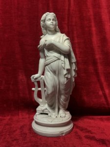 Antique Parian Ware Robed Lady Standing With Lyre Figurine Sculpture C1860 Circa - 1860 Composition - Hard Paste Porcelain Listing Description Antique Fine Quality Parian Ware Statue Of Ornately Robed Lady Standing Next To Lyre Instrument. Exquisitely Fine Details Of Face Hands & Feet. Chip Visible On Front Cylindrical Base. No Damage To Figure. Dimensions In Inches Height 14.5" X Width 6" For Further Information Please Call The Museum Curator On 07707 488566 Thankyou.