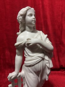 Antique Parian Ware Robed Lady Standing With Lyre Figurine Sculpture C1860 Circa - 1860 Composition - Hard Paste Porcelain Listing Description Antique Fine Quality Parian Ware Statue Of Ornately Robed Lady Standing Next To Lyre Instrument. Exquisitely Fine Details Of Face Hands & Feet. Chip Visible On Front Cylindrical Base. No Damage To Figure. Dimensions In Inches Height 14.5" X Width 6" For Further Information Please Call The Museum Curator On 07707 488566 Thankyou.