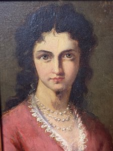 Late 19C Oil Portrait Of Lady Wearing Pearl Necklace Signed By Artist J Axmann. Circa - 1866 Composition- Oil On Board Front Facing Head And Shoulder Portrait Of Unknown Angelic Lady Sitter With Dark Hair, Hazel Eyes And Pronounced Facial Features. Wears Pink Gown Decorated With Eyelash Lace Detail And Eye Catching Three String Pearl Necklace. Exceptional Detailed Portrait By Very Accomplished And Well Known Artist J Axmann. Signed Top Right Corner By Artist And Set In Gilt Wood Frame. The Frame Showing Signs Of Wear Due To Age. Dimensions In Inches Height 11.5” Width 9 3/4”