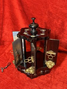 Antique Original Reuge Musical Cigarette Carousel Adorned With Painted Landscape Scenes Circa - Victorian 1890 Composition - Ebony Wood, Mother Of Pearl And Oils Listing Description Fine Quality Swiss Made Musical Cigarette Carousel Constructed In A Hexagonal Form. The Body Is Comprised Of Cylindrical Framework Hanging Six Doors Which Revolve (By Turning The Top Pinnacle CLOCKWISE To Open), Revealing Ornate Brass Individual Cigarette/Cigar Mounts. The Front Of Each Door Decorated With Fine Mother Of Pearl Inlays Intricately Over Painted With Quintessential Costal Town Landscape Scenes And Sailing Boats . Ornamental Scalloped Plinth Base Decorated With Floral Sprays Of Meadow Flowers To Match The Top Of The Carousel. Complete With Original Winding Key For Musical Element Which Plays Beautifully A Array Of Tunes. Video Available Of The Carousel Playing (Please Call If You Require The Video) Winding Keyhole On The Underside. Muiscal Switch On The Side Of The Carousel. Rare & Interesting Collectors Item. Condition - Very Good Antique Signs Of Wear To Paint Work Due To Age And Usage. In Good Working Order. Dimensions In Inches Height 11" Base Diam 7.5" For Further Pictures And Other Information Please Call 07376618513
